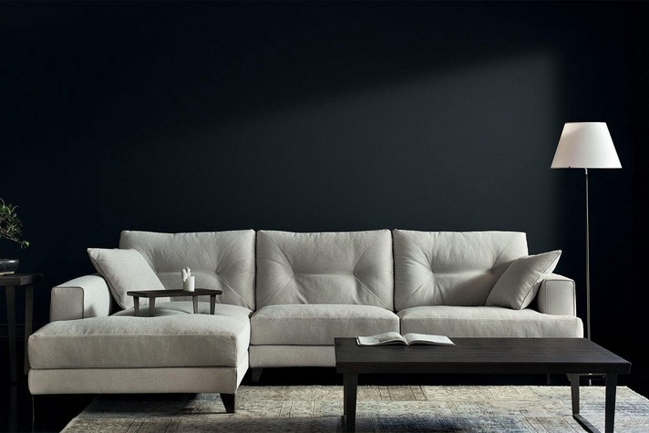 Gemütliches Sofa mit hoher Rückenlehne, Kissen mit Ziernähten und hohen Metall- oder Holzfüßen