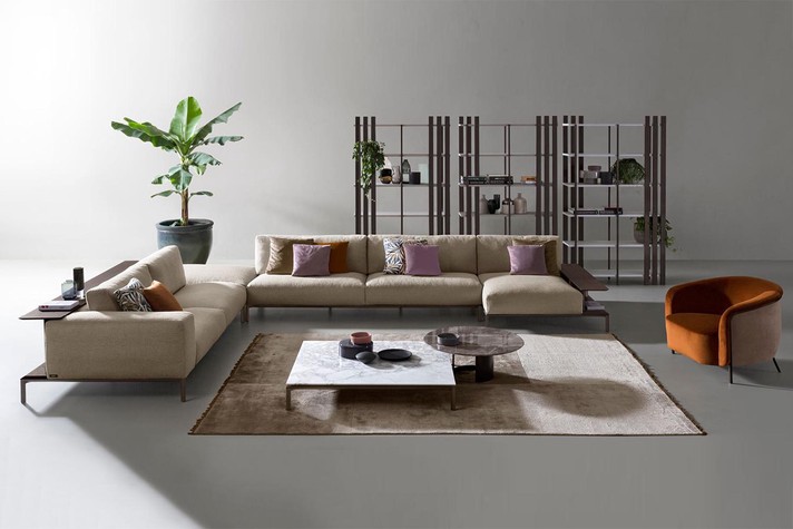 Modulares Sofa mit Bücherregal in der Rückenlehne und hohen Aluminiumfüßen