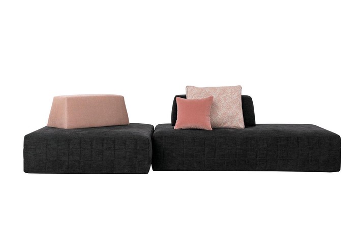 Ein 3-4-Sitzer mit asymmetrischen Linien und zweifarbigen Kissen.