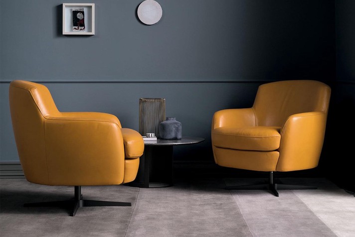 A set of two swivel armchair in yellow leather
