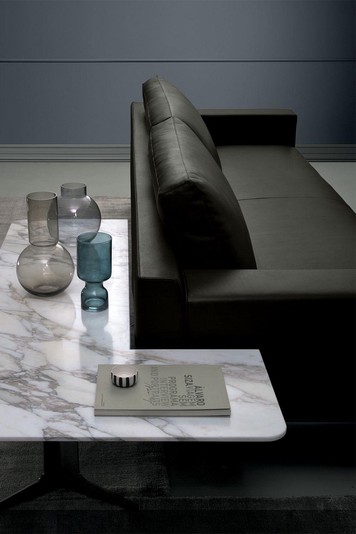 Corner coffee table placed behind the sofa