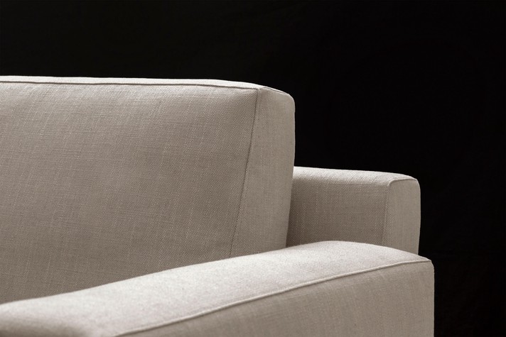 Details of the rigid back structure against which the goose down cushions are placed, and of the wide armrest