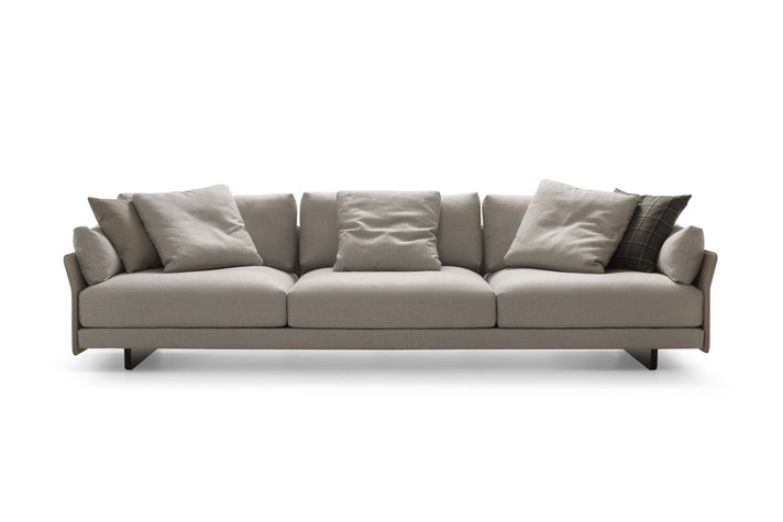 Linear sofa with narrow armrests and back covered in leather
