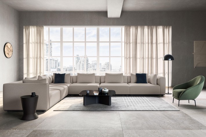 Large modular sofa upholstered in fabric, positioned in the room centre