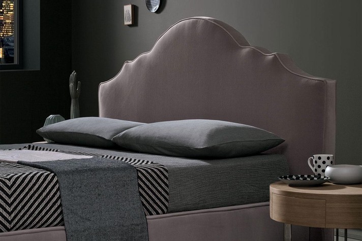 A romantic scalloped headboard with a modern clean lined twist