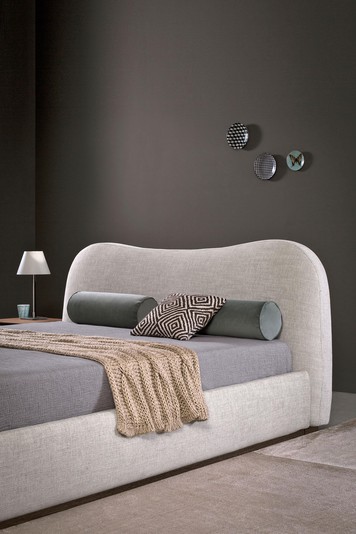 A curved headboard for a bedroom with a relaxed look