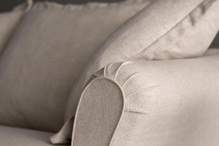 Détail de l'accoudoir en crosse avec passepoil et du coussin à volant