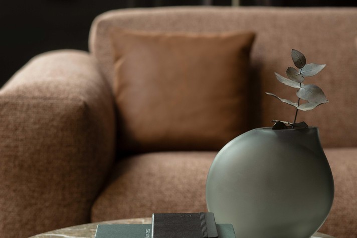 Détail de l'accoudoir large et du dossier avec coussin décoratif