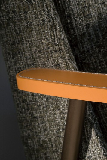 Détail de l'accoudoir en bois incurvé revêtu de cuir mince