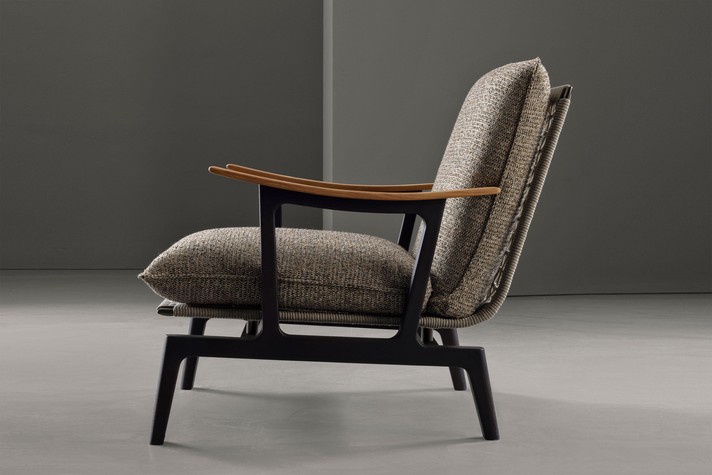 Vue de profil du fauteuil mettant en valeur la forme incurvée et ergonomique des accoudoirs en bois de noyer Canaletto