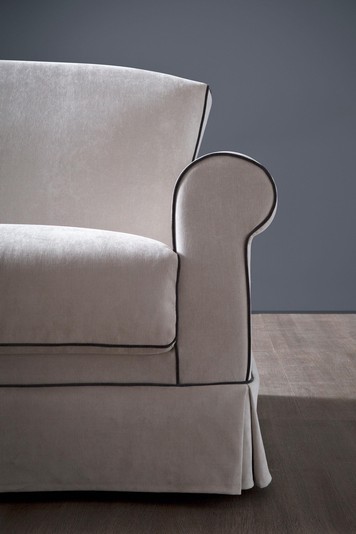Dettaglio del particolare bracciolo arrotondato e del rivestimento a mantovana, omaggio allo stile shabby chic