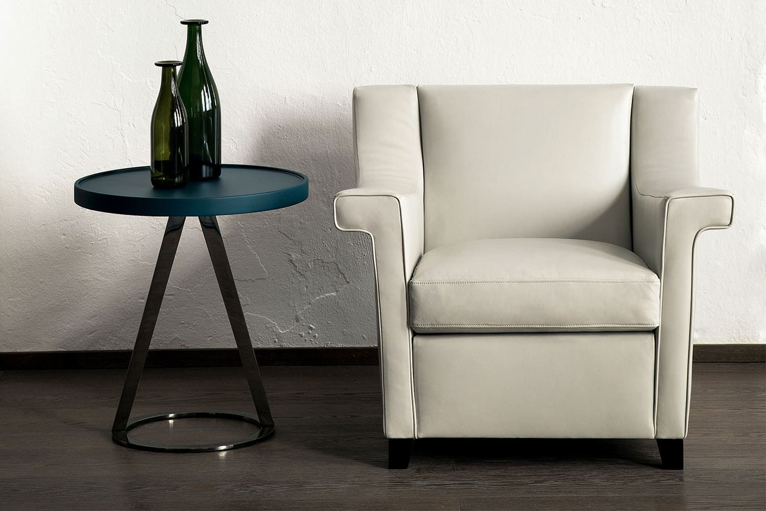 Modern slope-arm club chair with a low back, hardwood square tapered legs and distinctive winged arms